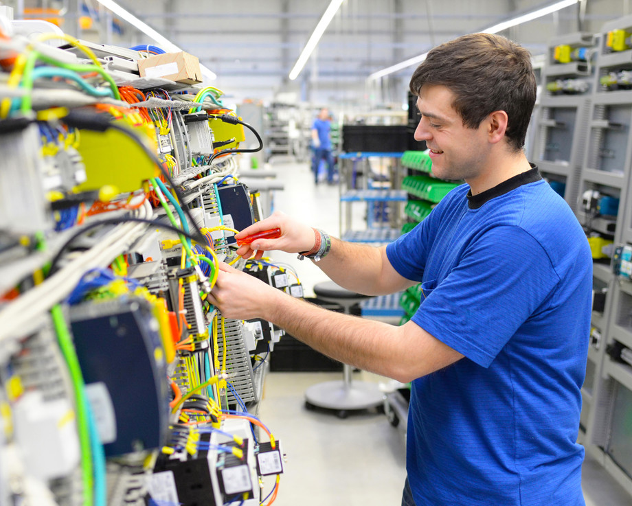 Ein Mann arbeitet in einer Fabrik an einer elektrischen Schaltung.